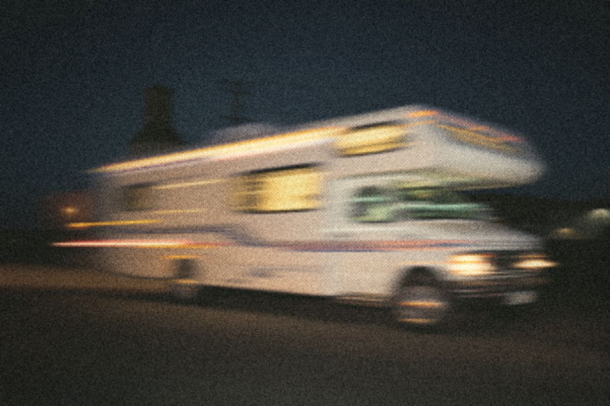 White motorhome rolling out of a gravel lot at dusk