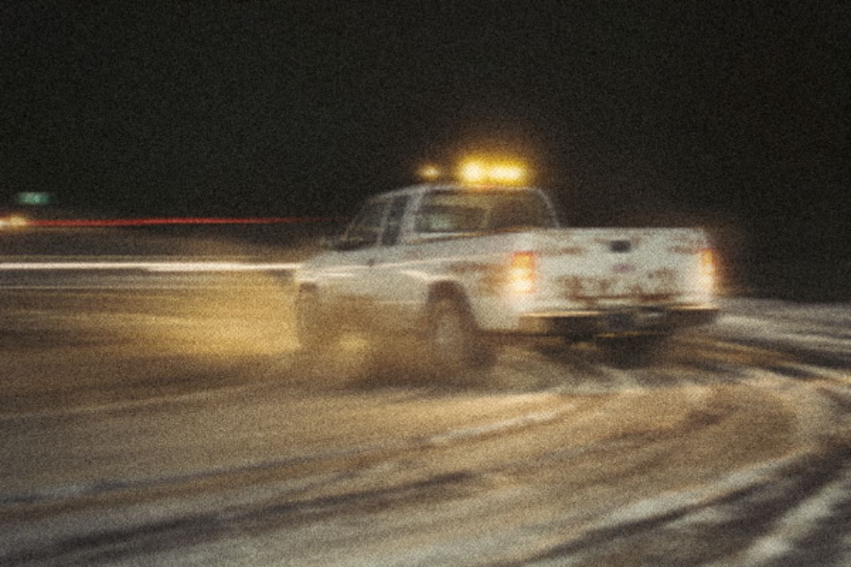 Muddy work truck throwing slush on a rural highway